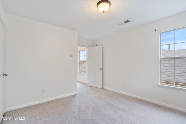 unfurnished room featuring carpet floors, baseboards, and a textured ceiling