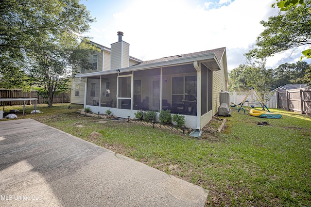 56 Lakeview Dr, Ocean Springs, MS 39564 - rear view of property with a sunroom, a trampoline, a fenced backyard, and a chimney