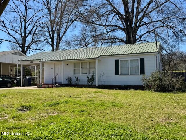 single story home with an attached carport, metal roof, and a front yard