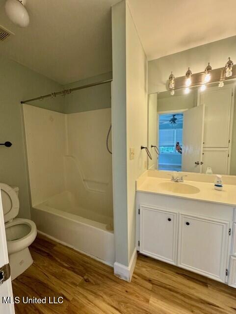 106 Laurel Ave, Natchez, MS 39120 - full bathroom featuring toilet, wood finished floors, vanity, shower / washtub combination, and baseboards