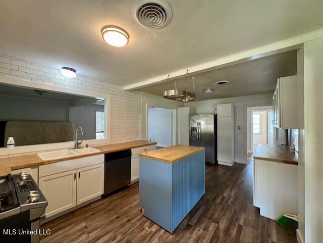 106 Laurel Ave, Natchez, MS 39120 - kitchen with butcher block countertops, stainless steel refrigerator with ice dispenser, dishwashing machine, a sink, and white cabinets