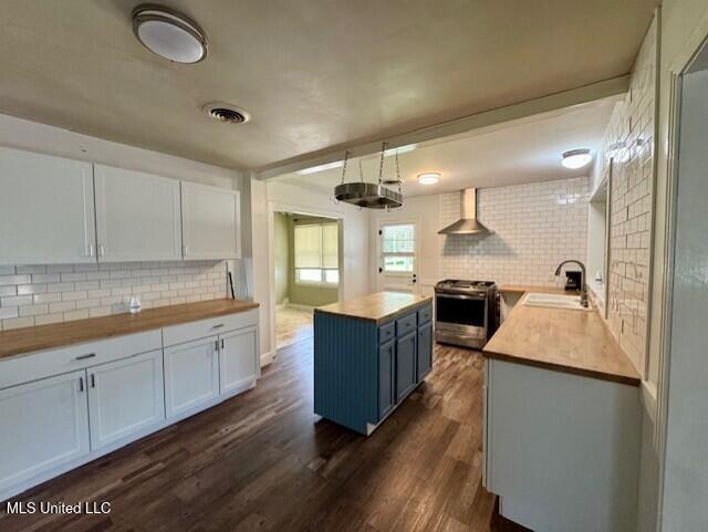 106 Laurel Ave, Natchez, MS 39120 - kitchen with wooden counters, stainless steel range oven, wall chimney range hood, and decorative backsplash