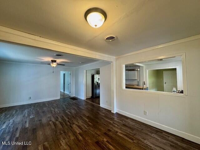 106 Laurel Ave, Natchez, MS 39120 - unfurnished living room featuring dark wood-type flooring, baseboards, ceiling fan, and crown molding
