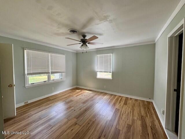106 Laurel Ave, Natchez, MS 39120 - empty room with ornamental molding, healthy amount of natural light, wood finished floors, ceiling fan, and baseboards