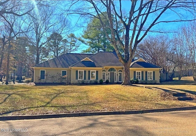 single story home featuring a front yard, fence, and stucco siding