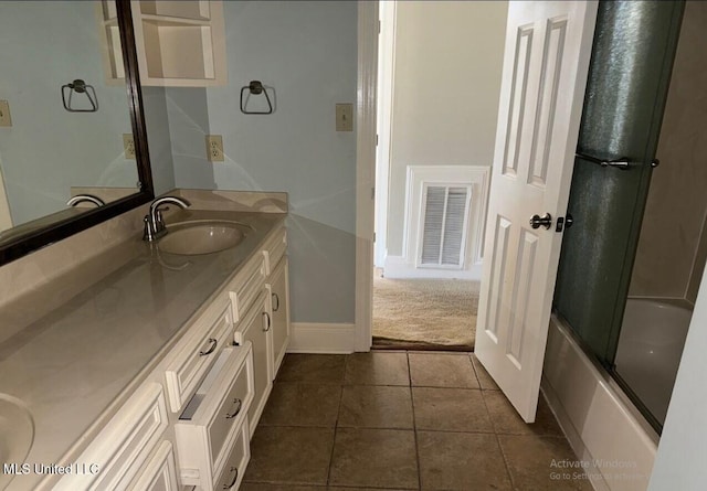 full bathroom with visible vents, a sink, tile patterned flooring, double vanity, and enclosed tub / shower combo