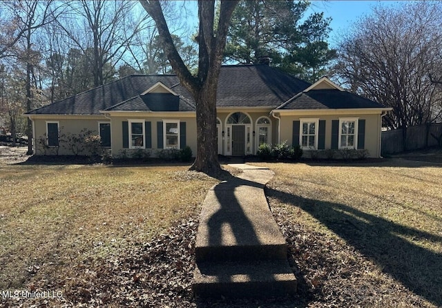 view of front of house featuring a front lawn, fence, and stucco siding