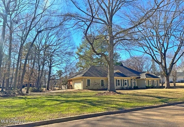 ranch-style house featuring stucco siding, an attached garage, and a front lawn