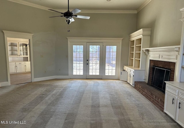 unfurnished living room with baseboards, light colored carpet, a brick fireplace, and crown molding