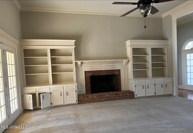 unfurnished living room featuring crown molding, a fireplace, and light colored carpet