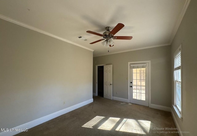 unfurnished room with visible vents, baseboards, carpet floors, ornamental molding, and a ceiling fan