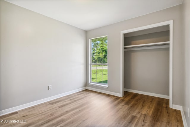 unfurnished bedroom featuring hardwood / wood-style flooring and a closet