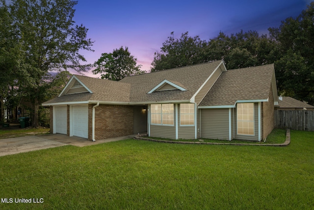 ranch-style home with a garage and a lawn