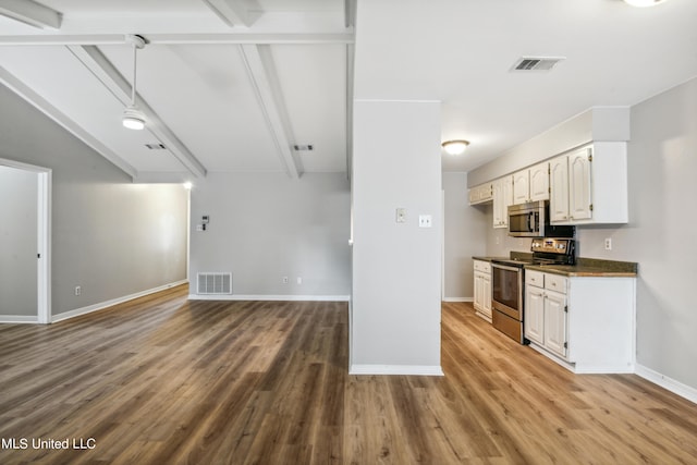 kitchen with appliances with stainless steel finishes, white cabinets, beam ceiling, and light hardwood / wood-style floors