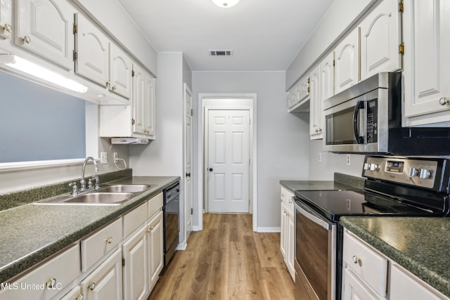 kitchen featuring sink, appliances with stainless steel finishes, white cabinetry, and light hardwood / wood-style floors