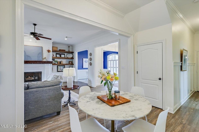 dining room with ceiling fan, crown molding, built in features, and hardwood / wood-style floors