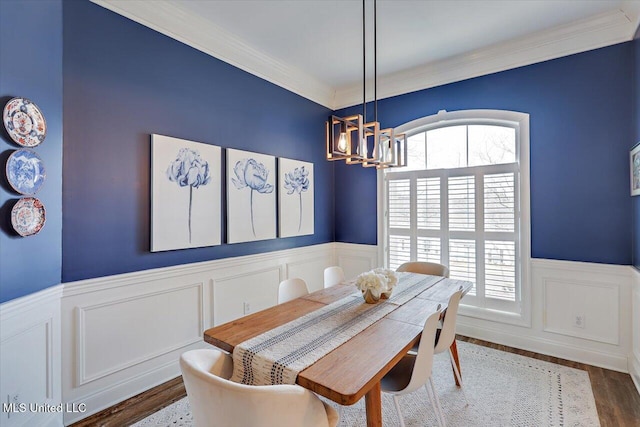 dining area with crown molding, dark hardwood / wood-style flooring, and an inviting chandelier