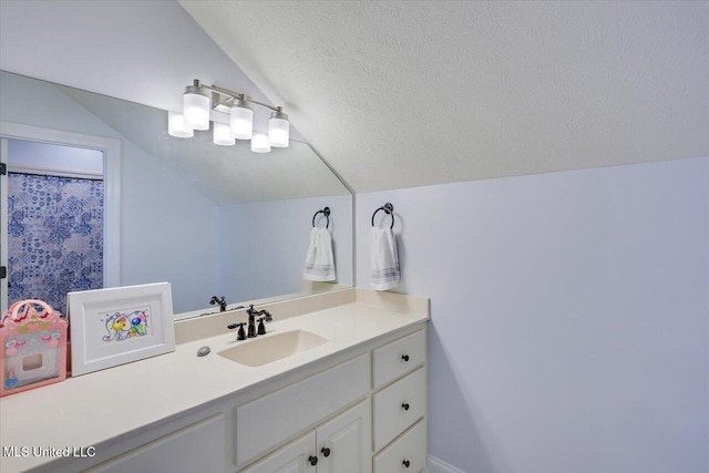 bathroom with lofted ceiling, vanity, and a textured ceiling