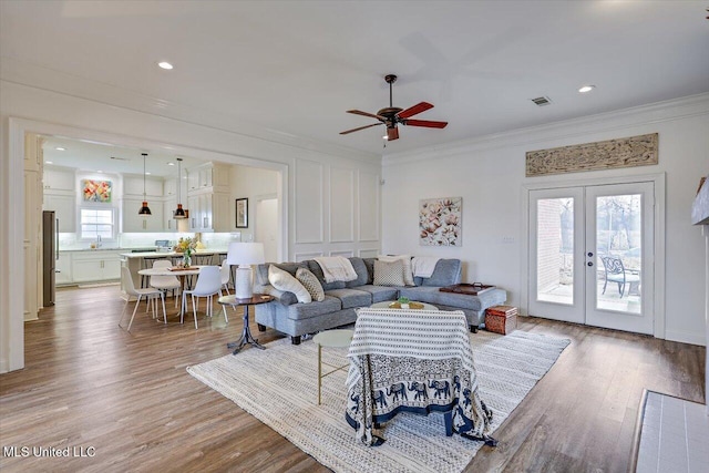 living room with ceiling fan, french doors, a wealth of natural light, and crown molding