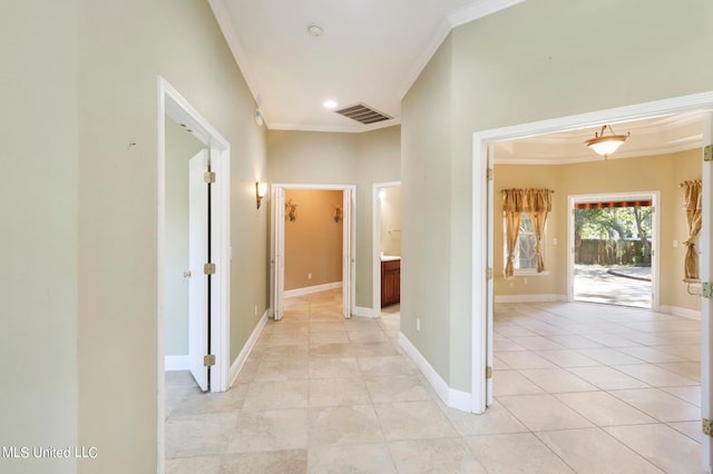 hallway with ornamental molding and light tile patterned flooring