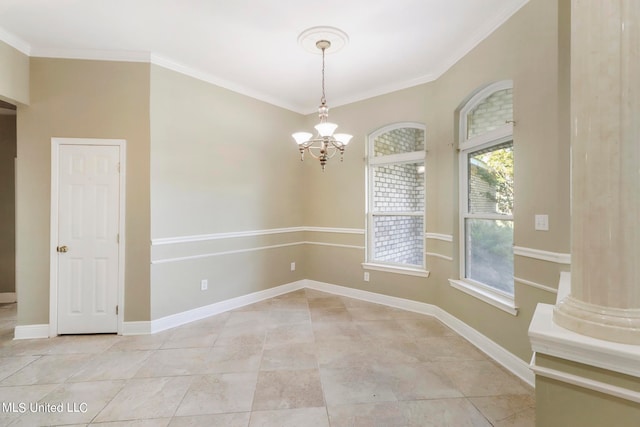 spare room with ornate columns, crown molding, and a chandelier