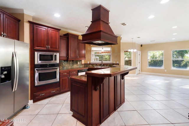 kitchen with sink, hanging light fixtures, an inviting chandelier, a kitchen bar, and appliances with stainless steel finishes