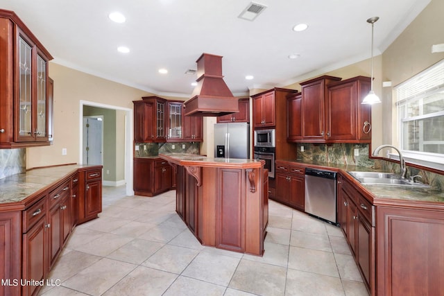 kitchen with sink, stainless steel appliances, pendant lighting, a kitchen island, and ornamental molding