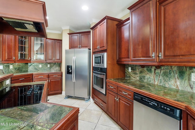 kitchen with appliances with stainless steel finishes, tasteful backsplash, ornamental molding, custom range hood, and light tile patterned flooring