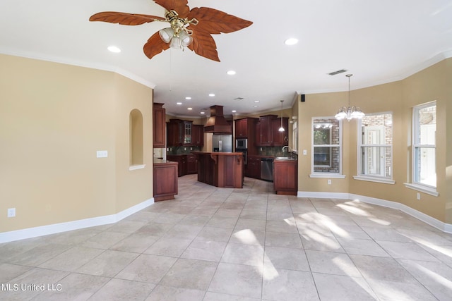 kitchen featuring appliances with stainless steel finishes, a kitchen island, hanging light fixtures, and ornamental molding