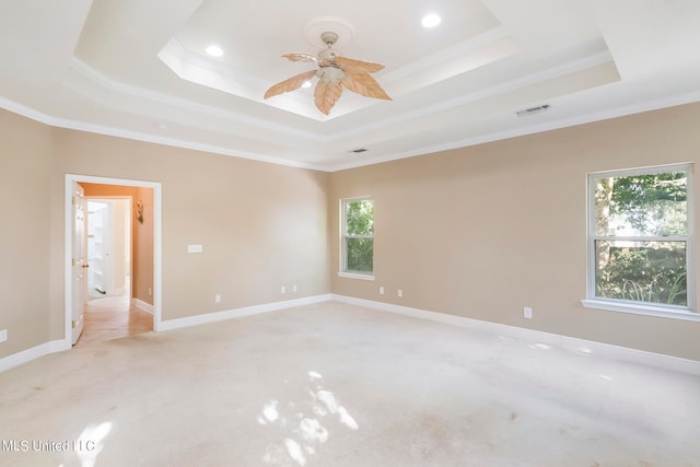 carpeted empty room with a tray ceiling and crown molding