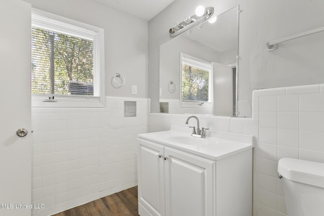 bathroom featuring toilet, vanity, tile walls, and hardwood / wood-style flooring