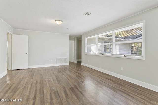 empty room featuring crown molding, a textured ceiling, and hardwood / wood-style flooring