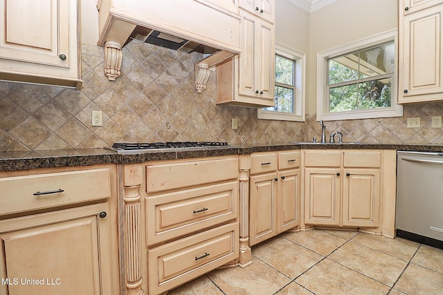 kitchen with appliances with stainless steel finishes, tasteful backsplash, custom range hood, light tile patterned floors, and sink