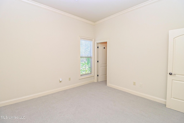 empty room featuring crown molding and light carpet