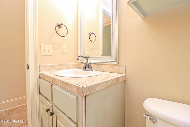 bathroom with toilet, tile patterned floors, and vanity