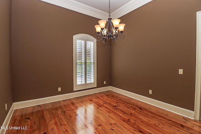 unfurnished room featuring crown molding, hardwood / wood-style flooring, and a chandelier