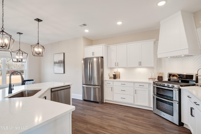 kitchen with appliances with stainless steel finishes, hanging light fixtures, and white cabinets