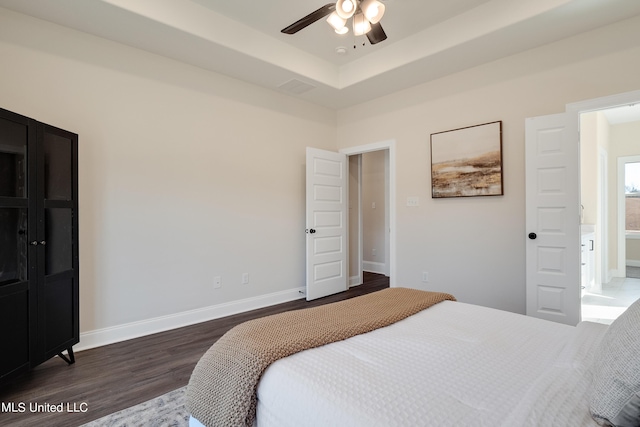 bedroom featuring wood finished floors, a ceiling fan, visible vents, and baseboards