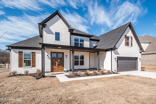 modern farmhouse featuring a garage, brick siding, roof with shingles, concrete driveway, and french doors