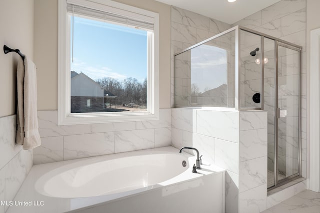 full bath featuring a stall shower, marble finish floor, and a bath