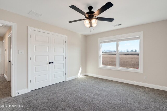 unfurnished bedroom featuring carpet flooring, a closet, and ceiling fan