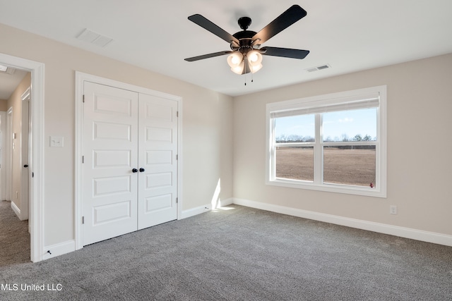 unfurnished bedroom featuring baseboards, visible vents, carpet floors, and a closet