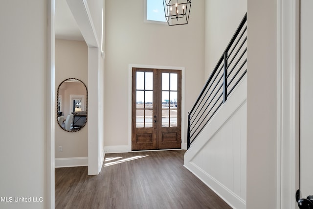 entrance foyer with french doors, a chandelier, and dark hardwood / wood-style flooring