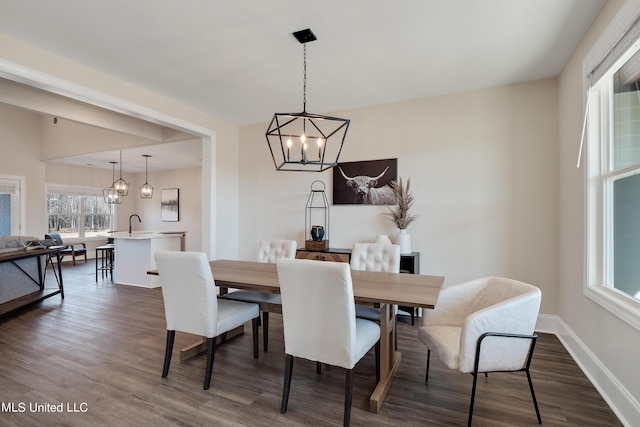 dining area with baseboards, an inviting chandelier, and dark wood-style flooring