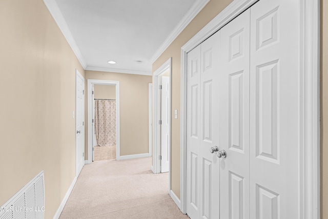 corridor with ornamental molding and light colored carpet