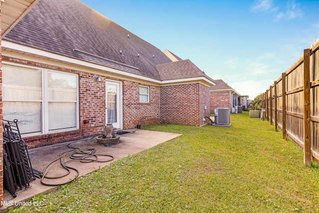 view of yard with central AC and a patio