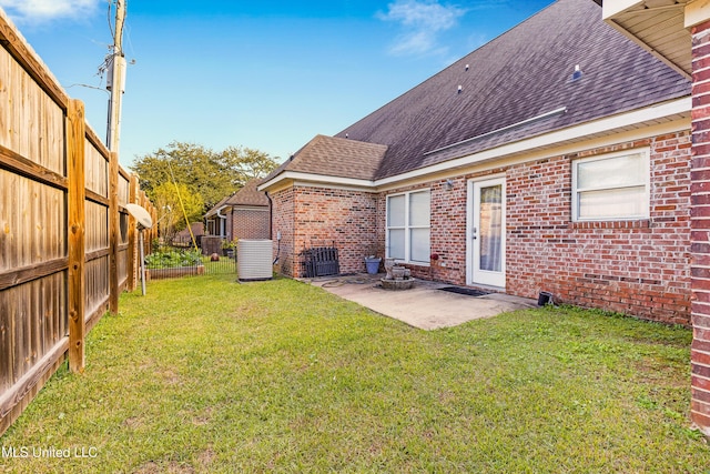 rear view of property featuring a lawn, cooling unit, and a patio