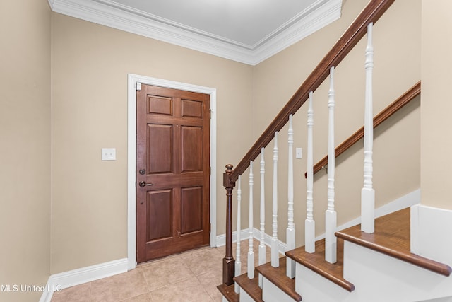 entryway with light tile patterned floors and ornamental molding