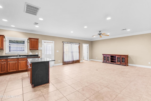 kitchen featuring a kitchen island, sink, light tile patterned flooring, ceiling fan, and crown molding