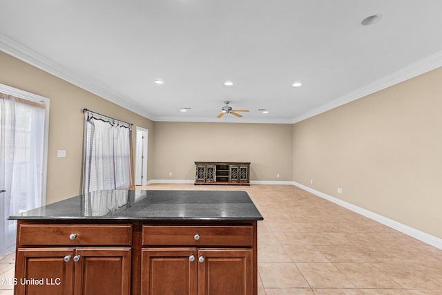 kitchen featuring a center island, dark stone counters, light tile patterned flooring, ceiling fan, and crown molding